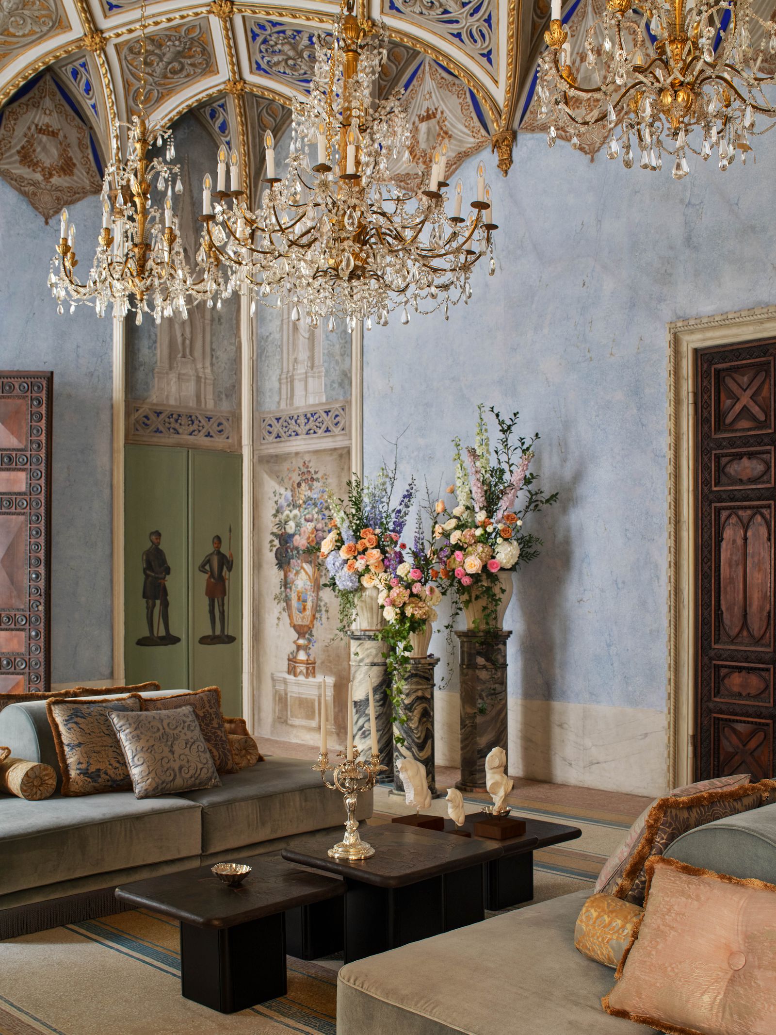 Image may contain Chandelier Lamp Home Decor Flower Flower Arrangement Plant Furniture Table Person and Couch